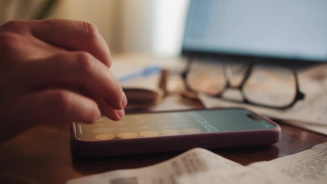 Woman sorts receipts using a calculator to track expenses at home. Budget planning or tax return from home.