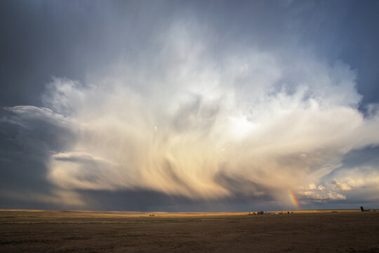 Dramatic Storm cloud and a rainbow forming over the Great Plains at sunset, Colorado, USA