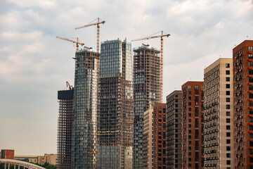 Fototapeta premium City skyline with new skyscrapers constructing next to modern residential buildings
