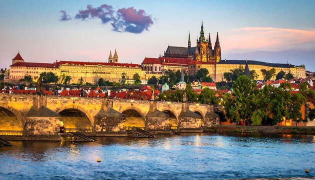 Prague cityscape at dusk. Arch bridge spans rippling water with castle backdrop under soft pink sky