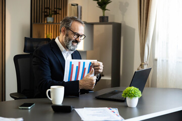 A professional man reviews graphs and data, showcasing success during a business video meeting. thumbs up