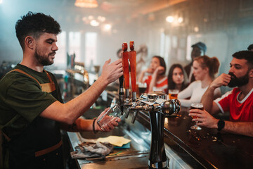 Bartender pouring beer in busy pub
