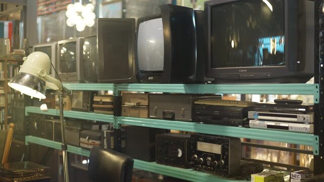 A dark retro styled room with old home appliances and a cathode ray tube TV.