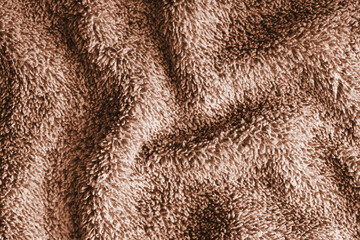 Close up, macro of crumpled brown terry towel fabric with wrinkles and soft waves. Fluffy microfiber texture with dense fibers, textile, material structure, detailed cloth abstract background © katyamaximenko