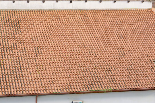 high angle shot of a large roof covered in traditional orange clay tiles on a mediterranean building, seamless pattern of terracotta roofing for heat protection and durability, real estate.