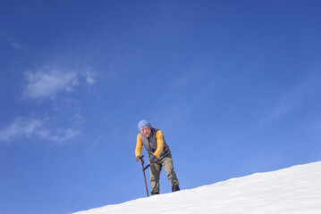 雪国で田舎暮らしの老人が杖を使ってリハビリをしている