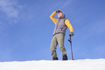 雪国で田舎暮らしの老人が杖を使ってリハビリをしている