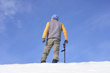 雪国で田舎暮らしの老人が杖を使ってリハビリをしている