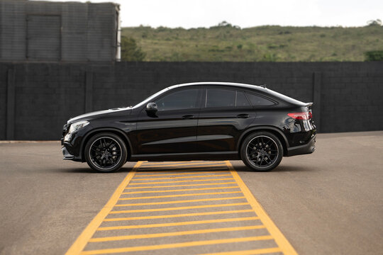 Black Mercedes GLE 63 side profile view, High performance luxury SUV coupe parked on empty street