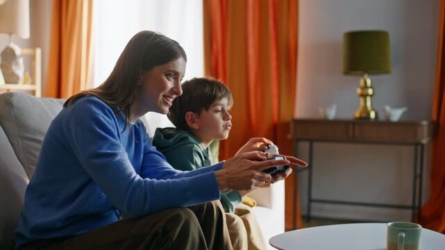 Mother son playing video game sitting sofa closeup. Joyful woman happy child