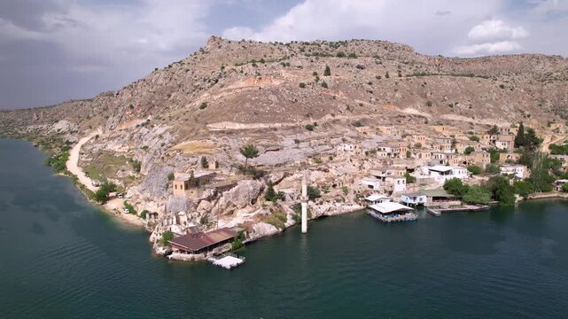 Experience a cinematic flight over the iconic half-submerged minaret of Savaşan Village in Halfeti. This footage highlights the haunting ruins and the turquoise depth of the Euphrates River.