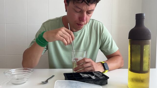 Reflective individual with drink and frozen tray nearby