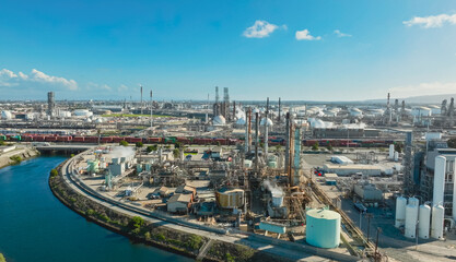 Aerial view of an expansive oil refinery with distillation towers and processing units against a...