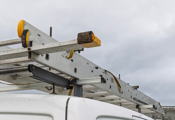 Close view of ladder rack system securing aluminium ladder on van © Tosh Lubek