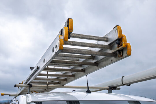 Aluminium extension ladder mounted on contractor van roof rack
