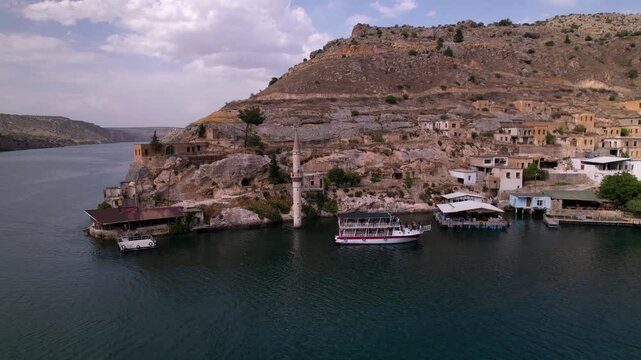 Experience a cinematic flight over the iconic half-submerged minaret of Savaşan Village in Halfeti. This footage highlights the haunting ruins and the turquoise depth of the Euphrates River.
