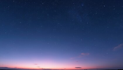 Fototapeta premium Vast night sky displays countless stars with gentle gradient from deep blue to soft purple at twilight. Clear horizon shows faint outlines of land under expansive celestial expanse, evoking peace.