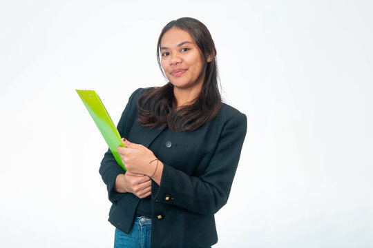 Portrait of smiling Indonesian woman wearing black blazer and white shirt, posing with fist under chin and looking at camera, isolated on white background.
