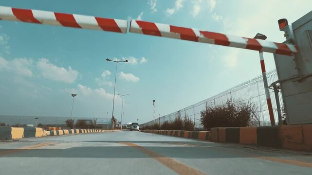 Footage of a vehicle barrier gate operating at a parking entrance showcasing the arm lifting to allow authorized cars through in a secure facility.