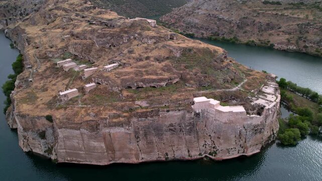 Drone flight over Rumkale, a historic archaeological site on the Euphrates and Merzimen confluence. Ancient Mesopotamian ruins and turquoise water. Cinematic travel scenery.