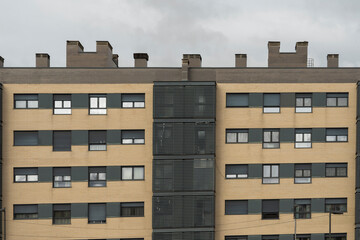 Contemporary facade with a repeating pattern of square windows that create a clean and orderly geometric effect in daylight.