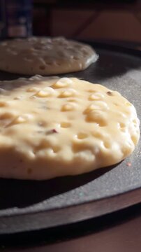 Close-up footage of pancake batter cooking in a hot pan, showing bubbles forming. Perfect for cooking tutorials, food preparation, and breakfast-related content.