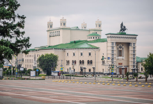 The salavat yulayev statue is overlooking the musical theatre in ufa, russia, on a cloudy day