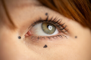 Fototapeta premium Female eye with cosmetic dots for beauty mapping