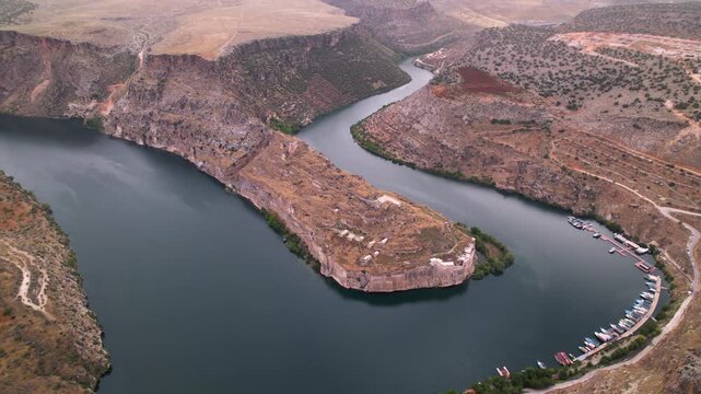 Drone flight over Rumkale, a historic archaeological site on the Euphrates and Merzimen confluence. Ancient Mesopotamian ruins and turquoise water. Cinematic travel scenery.
