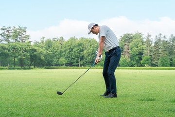 Male golfer playing golf on a golf course (tee shot, golf competition)