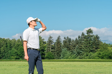 Male golfer wearing golf wear among the fresh greenery (golf course, academy, membership)