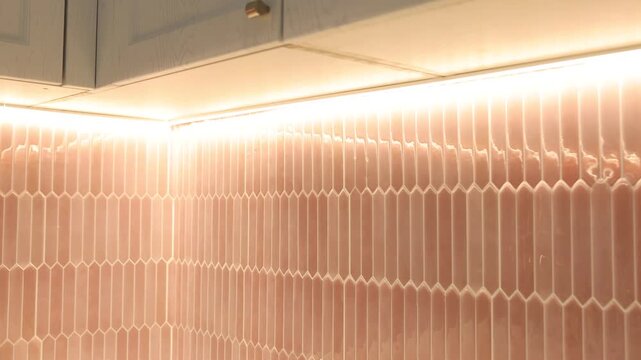 Peel and stick tiles on wall and cabinets in kitchen, closeup. Camera moving in