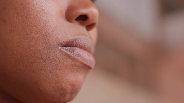 Outdoor black woman with dry windchapped lips, upward gaze, urban staircase background, natural light highlights skin texture, determined athlete vibe, grit and perseverance in candid portrait