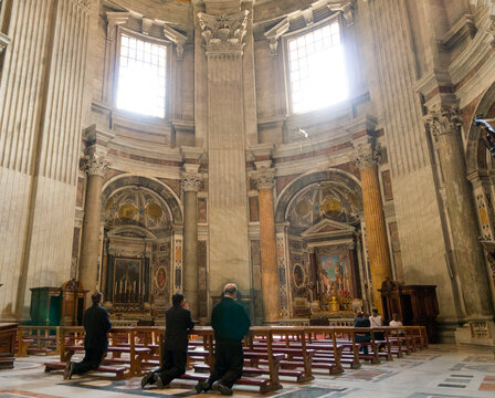 Italy, Rome, Vatican City.  Priests praying at alter in Saint Peter's Basilica.  