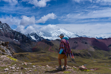 Naklejka premium Tourist enjoying view Ausangate Glacier Peru Perú glacial Peruvian Andes Nevado Auzangate Rainbow Mountain Vinicunca Vilcanota Cusco Region morning blue sky cloud Hatun Ritty dry rainy season