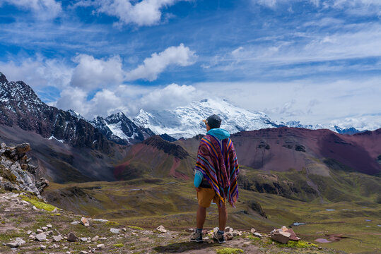 Tourist enjoying view Ausangate Glacier Peru Per&uacute; glacial Peruvian Andes Nevado Auzangate Rainbow Mountain Vinicunca Vilcanota Cusco Region morning blue sky cloud Hatun Ritty dry rainy season