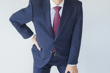 スーツを着た腰痛の男性　イメージ