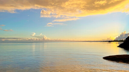 朝焼けの静かな海と黄金色に輝く幻想的な雲の風景　沖縄県今帰仁村 © creamfeeder