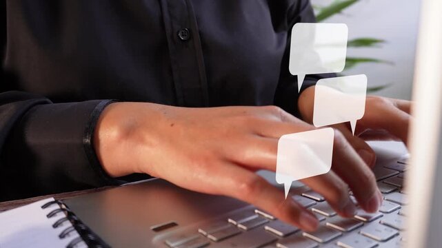 Close-up of a businesswoman working on her computer with an animated chat bubble.