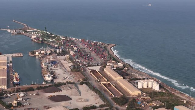 An aerial sunset over North Chennai, showcasing Chennai Port, container yards and the Bay of Bengal. Urban neighborhoods blend with industrial infrastructure, casting golden light on ship harbours.