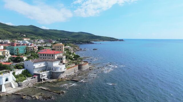 aerial of coastal Livorno Italy, shallow rocky shoreline off the Viale Amerigo Vespucci, 27-A coastal road, Tuscan port city, coastal breakwater