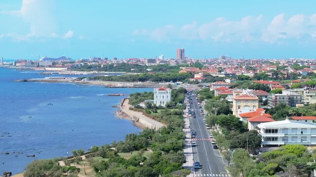 picturesque sideways aerial of suburban Livorno Italy looking deep north toward the industrial port and city center far ahead on the horizon