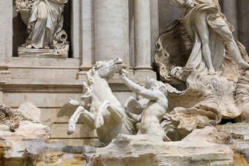 Naklejka premium Closeup view of the statue of the Triton struggling to control a restless winged sea-horse (hippocampus) at the famous Trevi Fountain in Rome, Italy.