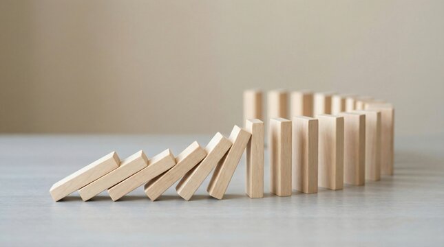 Wooden dominoes arranged in a curved line with some toppling over falling