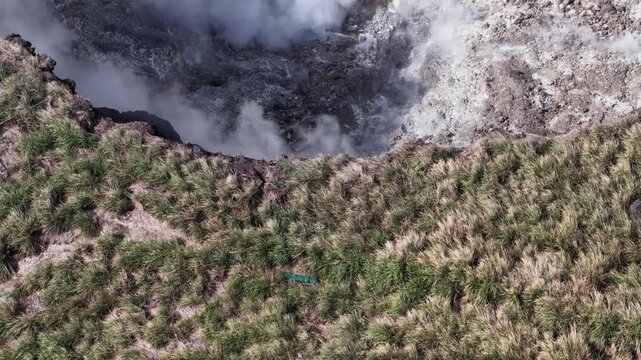 People watching geothermal fumarole steam vents in a volcanic crater