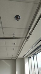 Fototapeta premium Fire sprinkler system and pipes installed on ceiling of modern building. Urban utility for safety, fire protection.