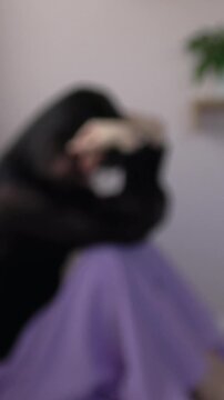 【縦動画】ぼかし背景素材: 部屋で一人、絶望し落ち込む女性　不安、孤独、うつ、メンタルヘルスイメージ