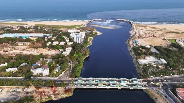 Aerial view of Napier Bridge, Chennai, showing cars and buses crossing the historic span over the river. The composition emphasizes geometry, traffic patterns, and the city&rsquo;s coastal infrastructure.