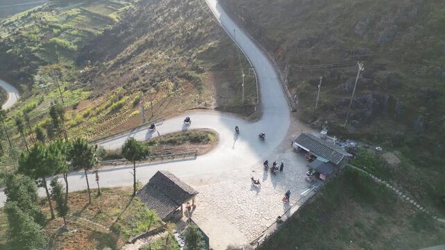 Breathtaking aerial footage of Thẩm M&atilde; Pass switchbacks on H&agrave; Giang Loop, Northern Vietnam. Captures rugged terrain, lush greenery, and winding roads in vibrant daylight for scenic vistas.
