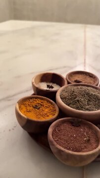 Arabian luxury chic. Expensive organic spices, scrubs, and natural powders in wooden bowls for a traditional hammam ritual. Elite high-end spa wellness treatments and rich lifestyle concept.